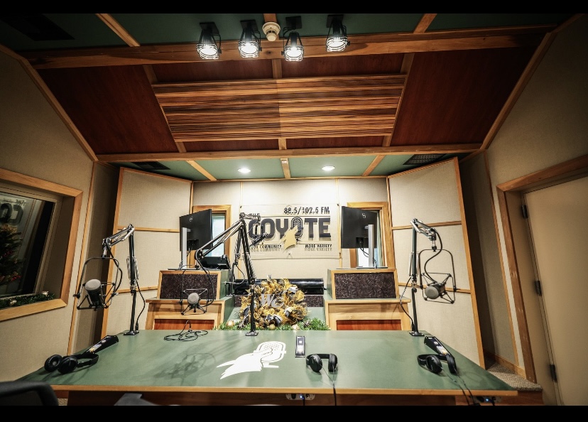 Coyote Radio logo in studio and table with microphones